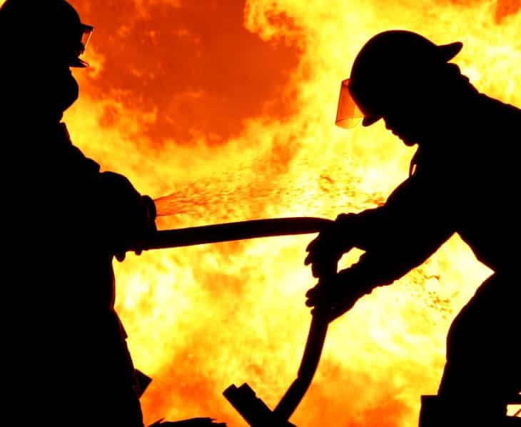 Imágen representativa para Seguro de Incendio para Crédito Hipotecario y Empresas, En la imágen aparecen dos bomberos en un incendio.
